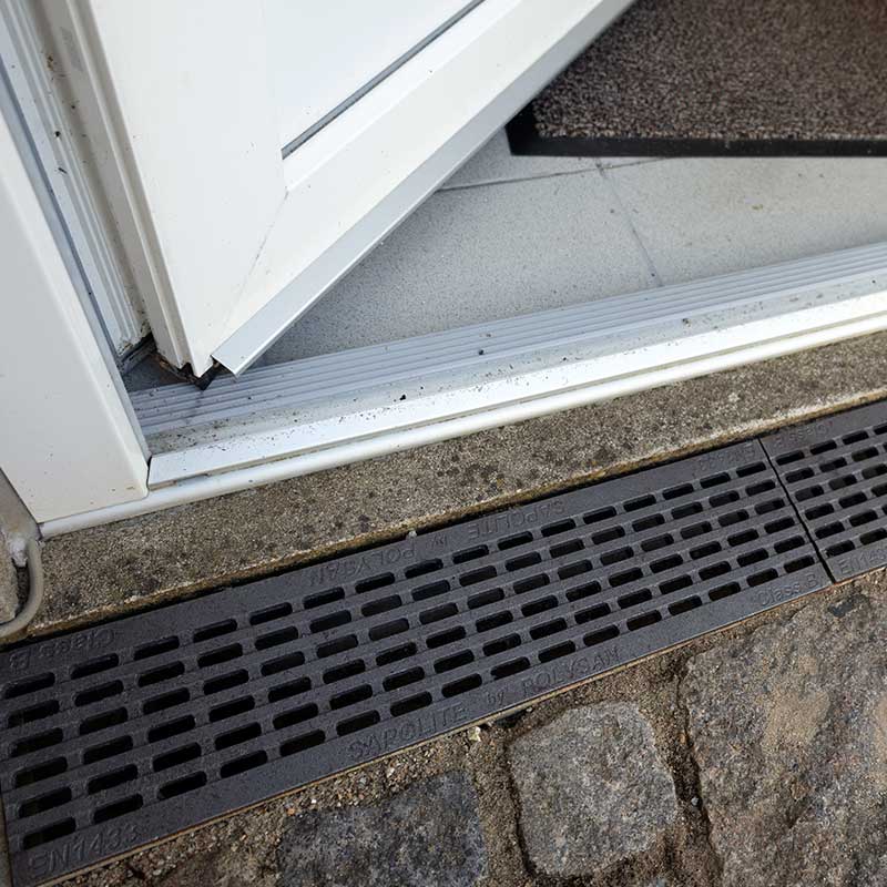 Dræn med rist foran hoveddør Dræn med rist foran hoveddør